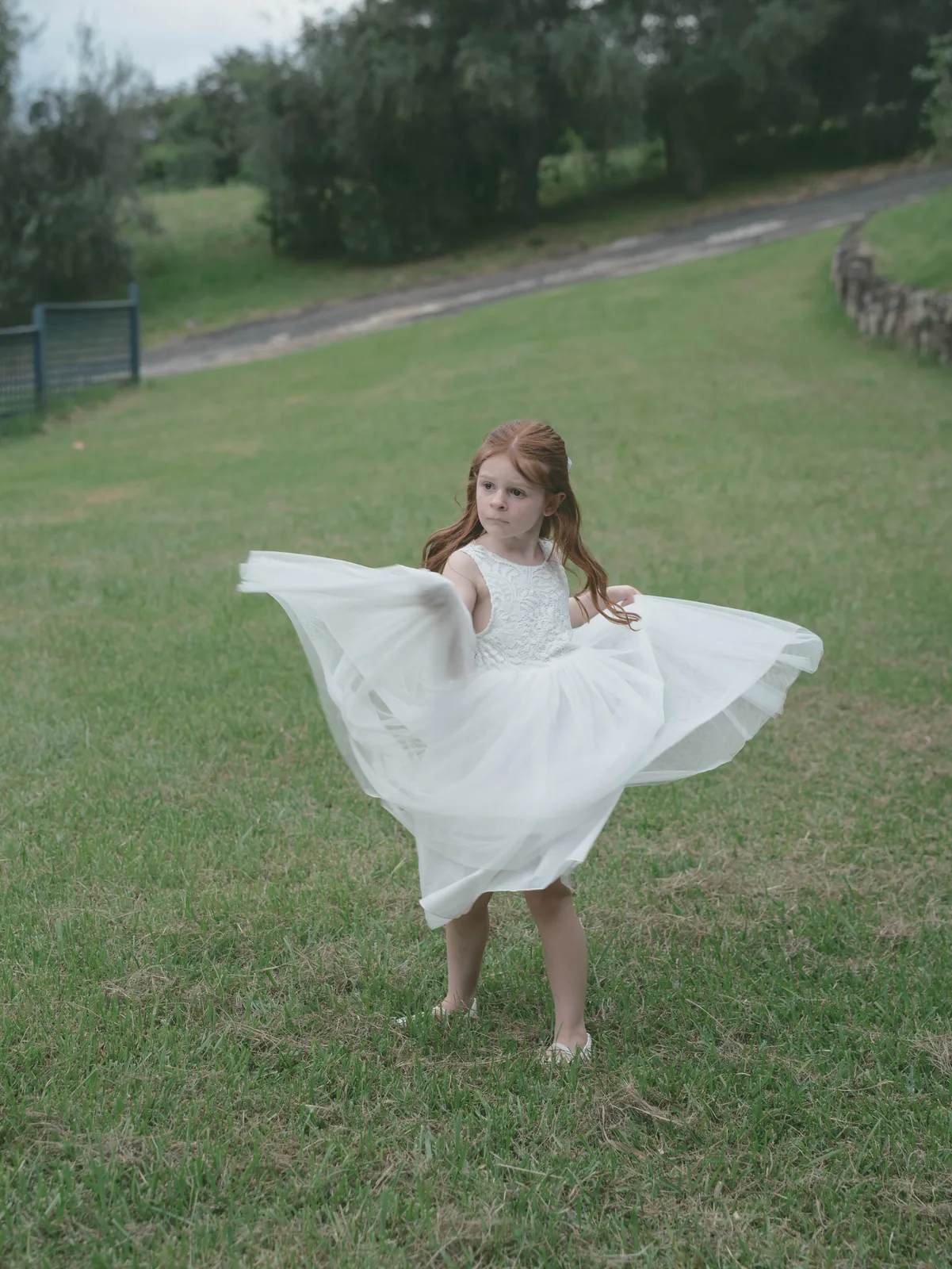 Flower girl twirling white dress in garden – Japanese documentary wedding photographer Sydney
